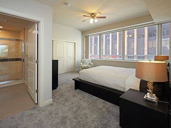 a bedroom with a bed and a window and a ceiling fan